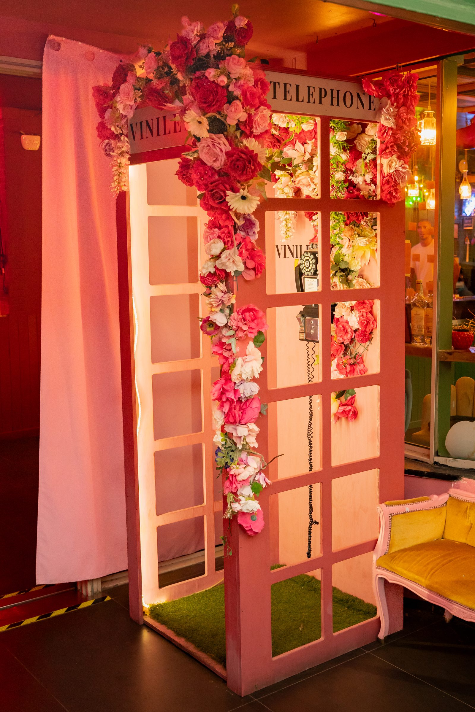 La cabina telefonica rosa piena di fiori